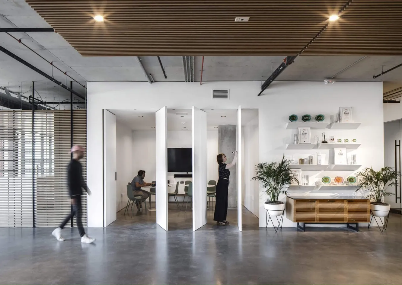 Modern office with open white meeting rooms and people at work